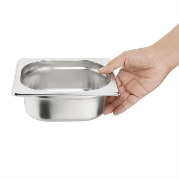 Hand holding stainless steel food pan insert